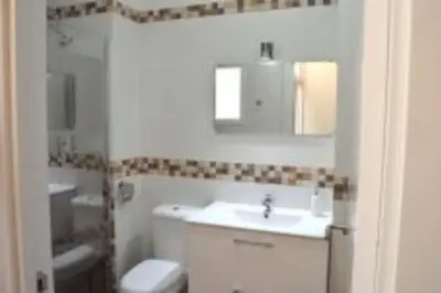 a white bathroom with a sink and a toilet at APARTAMENTO VEEDOR BULEVAR DE LOS SUEÑOS in Cádiz