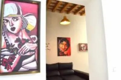 a painting of a woman in a hat on a wall at APARTAMENTO VEEDOR BULEVAR DE LOS SUEÑOS in Cádiz