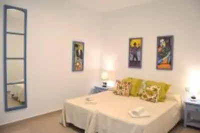 a white room with a bed and some pictures on the wall at APARTAMENTO VEEDOR BULEVAR DE LOS SUEÑOS in Cádiz