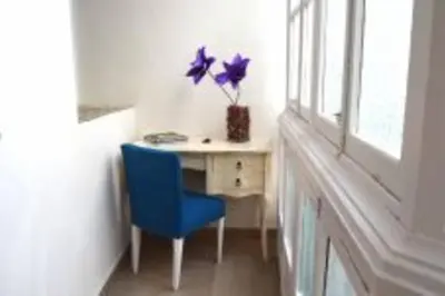 a desk with a blue chair and a vase with purple flowers at APARTAMENTO VEEDOR BULEVAR DE LOS SUEÑOS in Cádiz