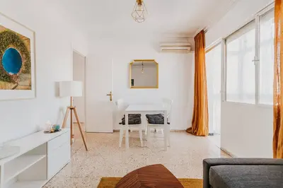 a white living room with a table and chairs at Apartamento Valdés - Ole Solutions in El Puerto de Santa María