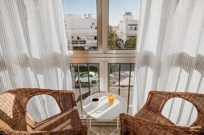 a balcony with two chairs and a table and two windows at Apartamento Valdés - Ole Solutions in El Puerto de Santa María