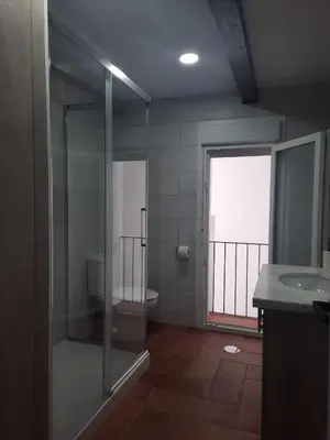 a bathroom with a shower and a toilet and a window at El rincón de Manolita #3 in Bornos
