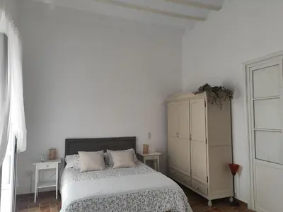 a white bedroom with a bed and a cabinet at Estreno centro y playa Cádiz in Cádiz
