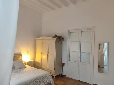 a bedroom with a bed and a cabinet and a mirror at Estreno centro y playa Cádiz in Cádiz