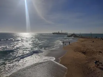 a group of people walking on the beach at Estreno centro y playa Cádiz in Cádiz