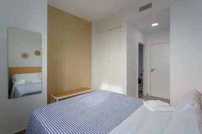 a bedroom with a blue and white bed and a mirror at POSEIDON Beach Apartment & parking by Cadiz4Rentals in Cádiz