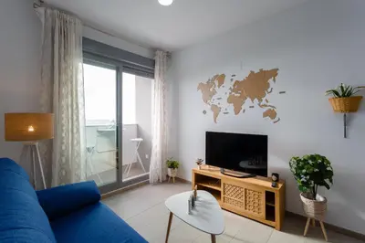 a living room with a blue couch and a tv at POSEIDON Beach Apartment & parking by Cadiz4Rentals in Cádiz