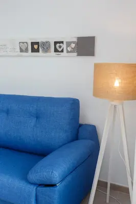 a blue couch sitting next to a lamp at POSEIDON Beach Apartment & parking by Cadiz4Rentals in Cádiz