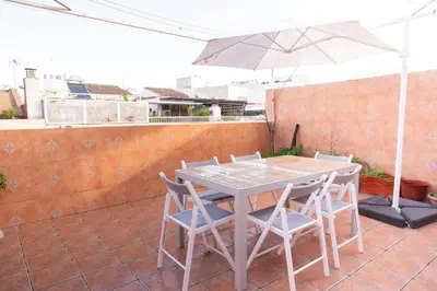a table and chairs with an umbrella on a patio at Casa RECREO in Cádiz