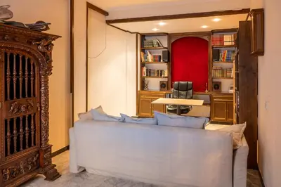 a living room with a white couch and a red chair at Casa RECREO in Cádiz