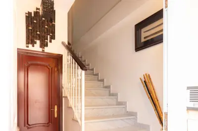 a staircase in a home with a brown door at Casa RECREO in Cádiz