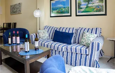 a living room with a couch and a table with wine bottles at Cozy Apartment In Sanlúcar De Barrameda in Sanlúcar de Barrameda