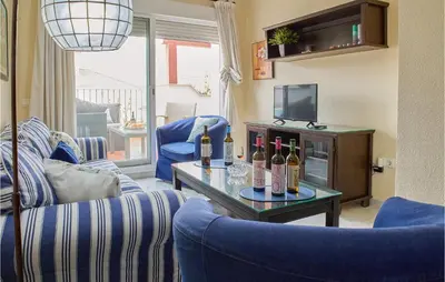 a living room with a couch and a table with bottles of wine at Cozy Apartment In Sanlúcar De Barrameda in Sanlúcar de Barrameda