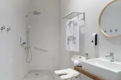 a white bathroom with a sink and a shower at CASA DE LA VEGA SUITES in Chiclana de la Frontera
