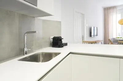 a kitchen with a sink in a white kitchen at CASA DE LA VEGA SUITES in Chiclana de la Frontera