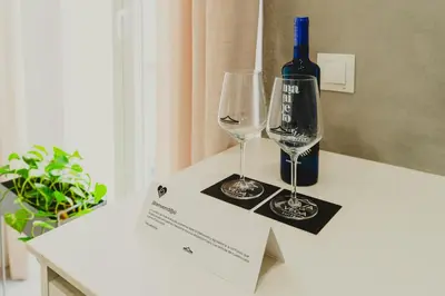 a bottle of wine and two wine glasses on a counter at CASA DE LA VEGA SUITES in Chiclana de la Frontera