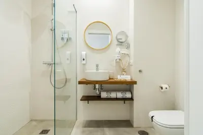 a bathroom with a toilet and a sink and a mirror at CASA DE LA VEGA SUITES in Chiclana de la Frontera
