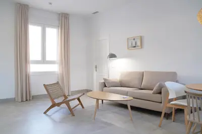 a living room with a couch and a table at CASA DE LA VEGA SUITES in Chiclana de la Frontera