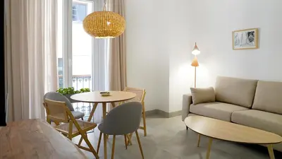 a living room with a couch and a table at CASA DE LA VEGA SUITES in Chiclana de la Frontera