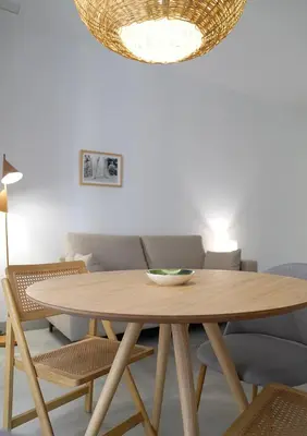 a dining room with a wooden table and chairs at CASA DE LA VEGA SUITES in Chiclana de la Frontera