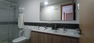 a bathroom with a sink and a toilet and a mirror at Geranio Chipionahome in Chipiona