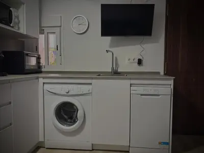 a kitchen with a sink and a washing machine at Geranio Chipionahome in Chipiona