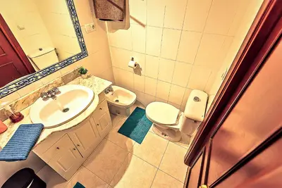 a bathroom with a sink and a toilet and a mirror at Misericordia Central 4-Bedroom Apartment with Lift in El Puerto de Santa María