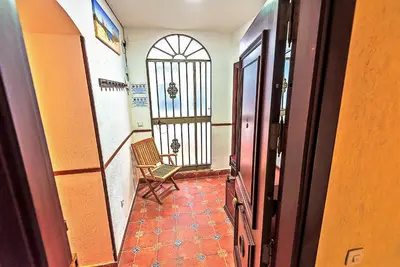 a hallway with a chair and a door with a window at Misericordia Central 4-Bedroom Apartment with Lift in El Puerto de Santa María