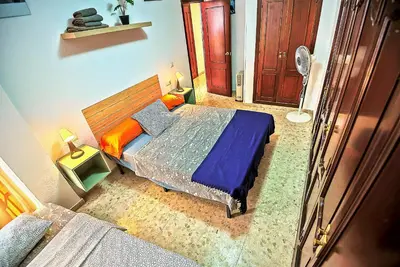 a bedroom with a bed with blue sheets and orange pillows at Misericordia Central 4-Bedroom Apartment with Lift in El Puerto de Santa María