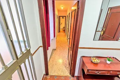 an empty hallway with a table and a window at Misericordia Central 4-Bedroom Apartment with Lift in El Puerto de Santa María