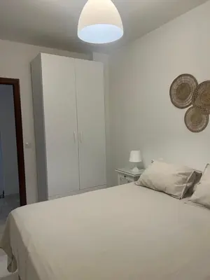 a white bedroom with a bed and a white cabinet at Casa vacacional equipada in Lebrija