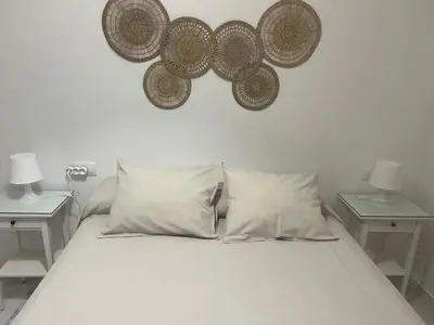 a bedroom with a bed with two tables and two lamps at Casa vacacional equipada in Lebrija