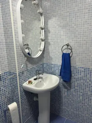 a blue tiled bathroom with a sink and a mirror at Casa vacacional equipada in Lebrija