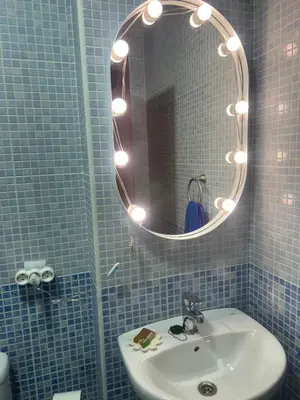 a blue tiled bathroom with a sink and a mirror at Casa vacacional equipada in Lebrija
