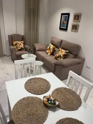 a living room with a couch and a table and chairs at Casa vacacional equipada in Lebrija