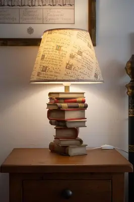 a stack of books sitting on a table with a lamp at Acogedor Piso Centro Sanlucar de Barrameda in Sanlúcar de Barrameda