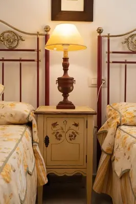 a lamp on a night stand next to two beds at Acogedor Piso Centro Sanlucar de Barrameda in Sanlúcar de Barrameda