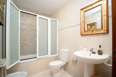 a bathroom with a toilet and a sink and a mirror at Acogedor Piso Centro Sanlucar de Barrameda in Sanlúcar de Barrameda