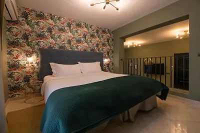 a bedroom with a large bed with a green blanket at Boutique Suites in Arcos de la Frontera