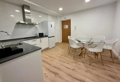 a kitchen with a table and chairs in a room at Apartamentos La Muralla Grupo AC Gestion in Cádiz