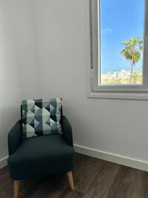 a chair sitting in a room with a window at Apartamentos La Muralla Grupo AC Gestion in Cádiz