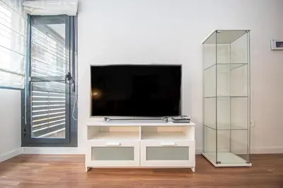a living room with a tv on a white cabinet at Apartamento La Luna Nueva en Cádiz in Cádiz