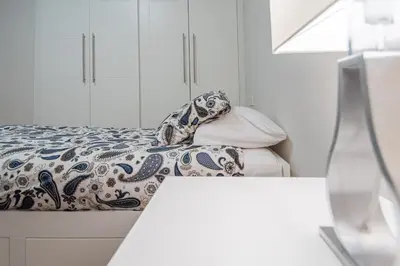 a bedroom with a bed with a blanket and pillows at Apartamento La Luna Nueva en Cádiz in Cádiz