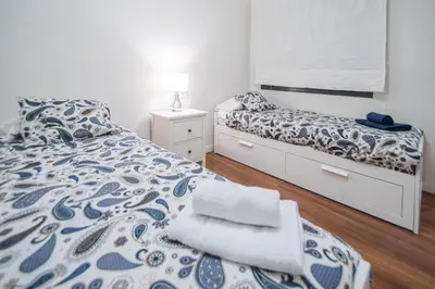 a bedroom with two beds with blue and white sheets at Apartamento La Luna Nueva en Cádiz in Cádiz