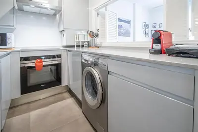 a kitchen with a washing machine under a counter at Apartamento La Luna Nueva en Cádiz in Cádiz