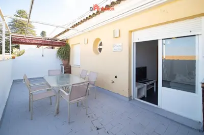 a patio with a table and chairs and a television at El Anfitrión - Paleobull Castillo in Sanlúcar de Barrameda