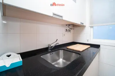 a kitchen with a stainless steel sink and a window at El Anfitrión - Paleobull Castillo in Sanlúcar de Barrameda