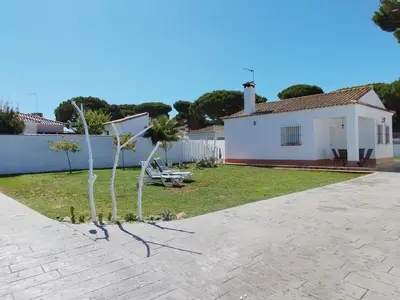 a house with a palm tree in the yard at Casita Alejandro in Chiclana de la Frontera