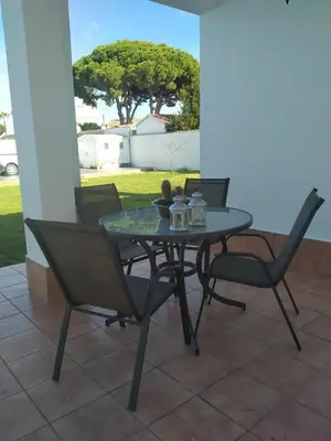 a glass table and chairs on a patio at Casita Alejandro in Chiclana de la Frontera
